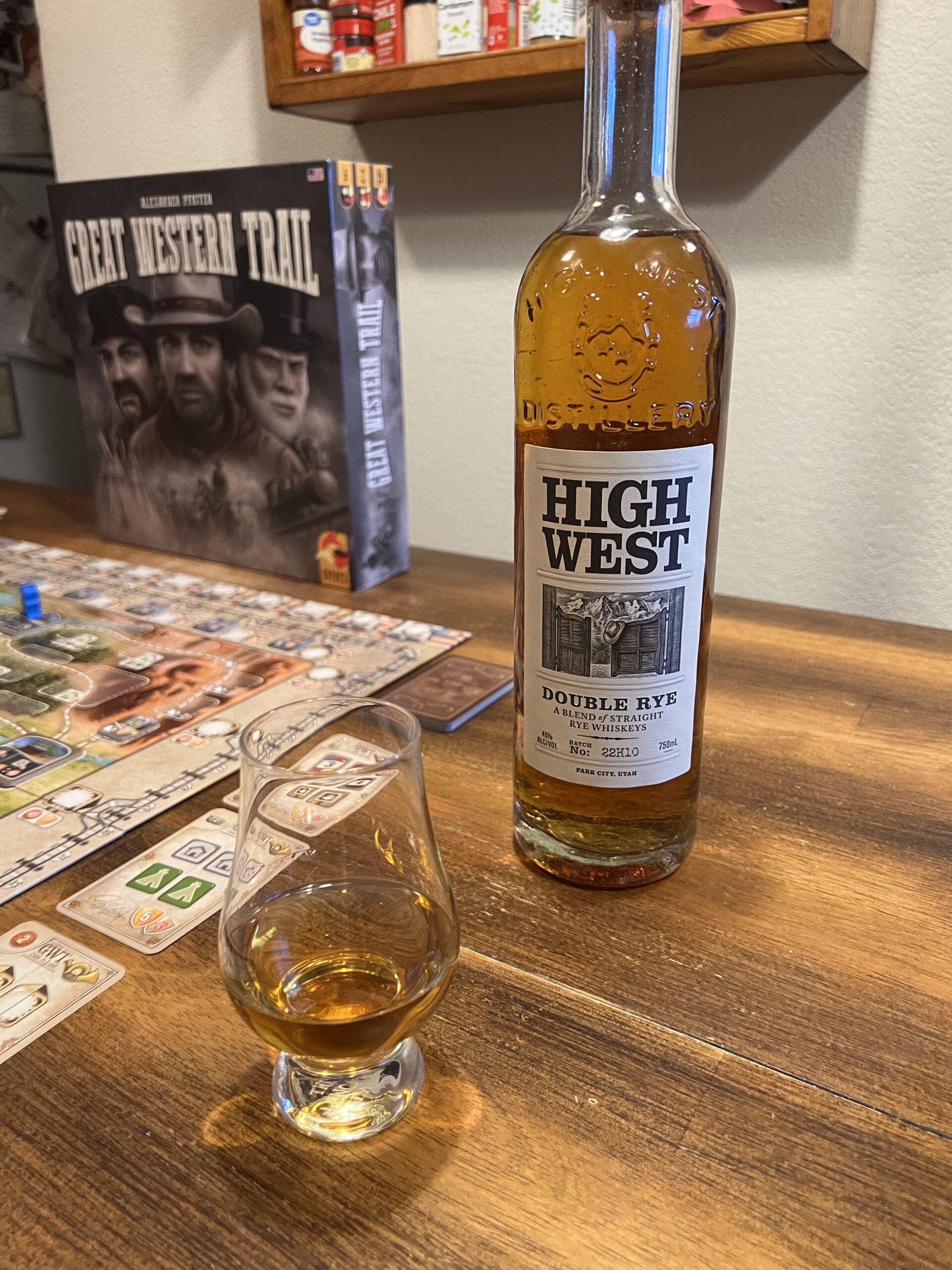 A glass of whiskey, a bottle of High West Double Rye, and Great Western Trail.